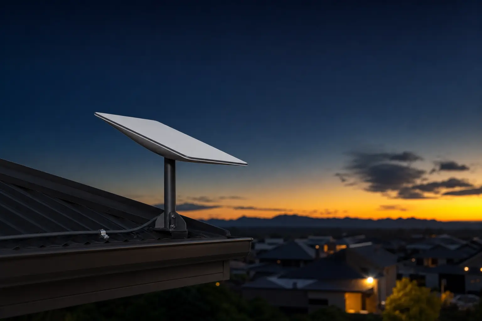 Low-profile satellite internet dish installed on a suburban roof at dusk